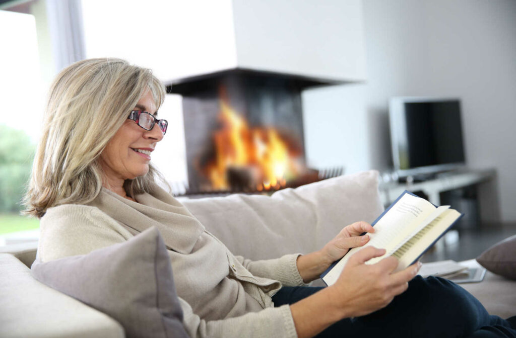 Mature woman reading on the couch.
