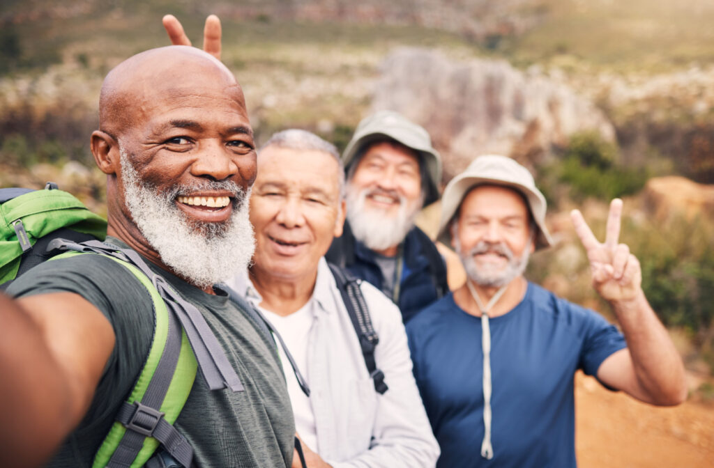 A group of seniors hiking in a national park, smiling and looking directly at the camera.