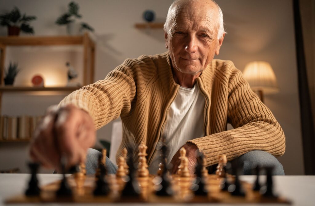 Smiling senior man playing chess.