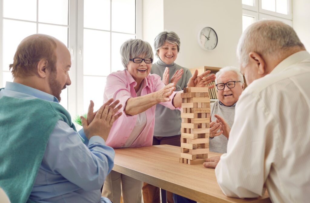 A group of senior residents excitedly play Jenga together.