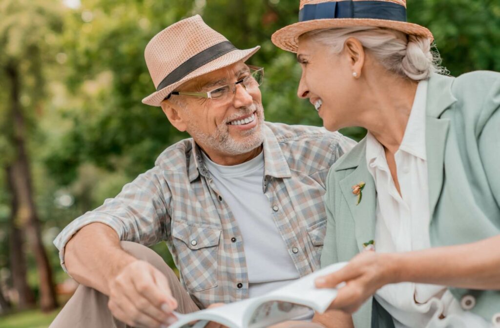 A senior couple enjoy each other’s company outdoors, spending their free time reading together without the hassle of chores