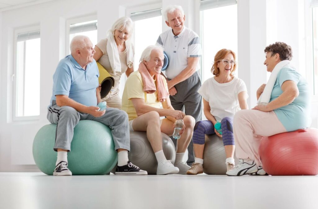 A group of seniors wearing colorful clothing socializing after a fitness class