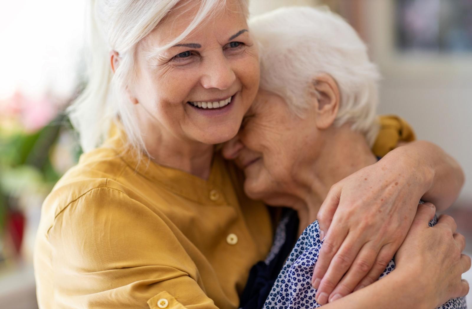 a senior embracing her elderly parent