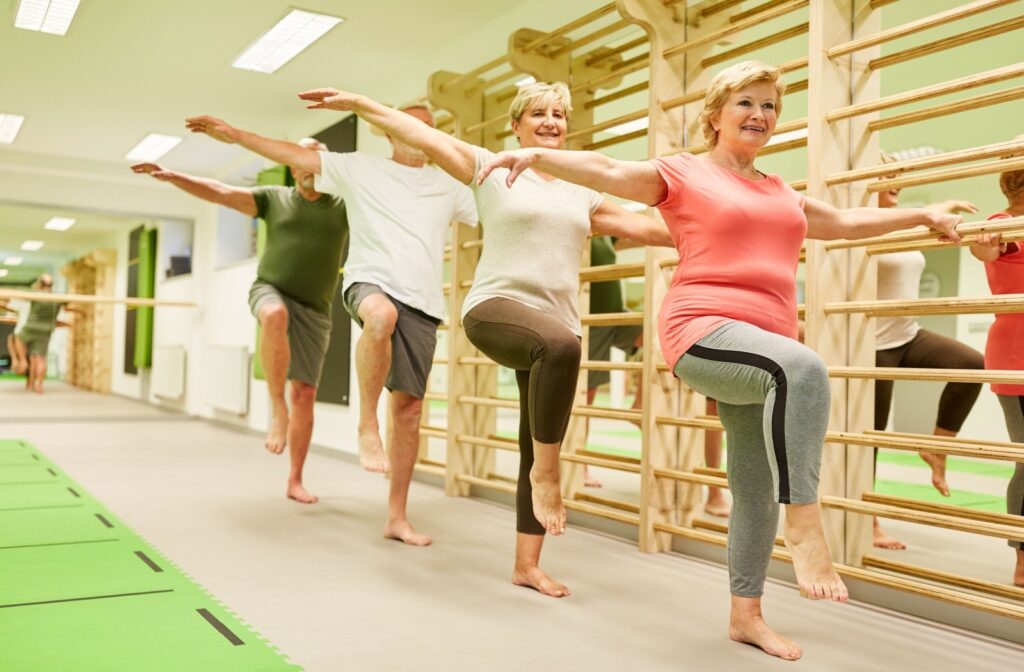 A group of senior friends participate in a yoga/balance exercise class