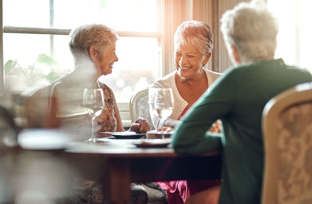 A group of senior friends smile and reminisce over dinner