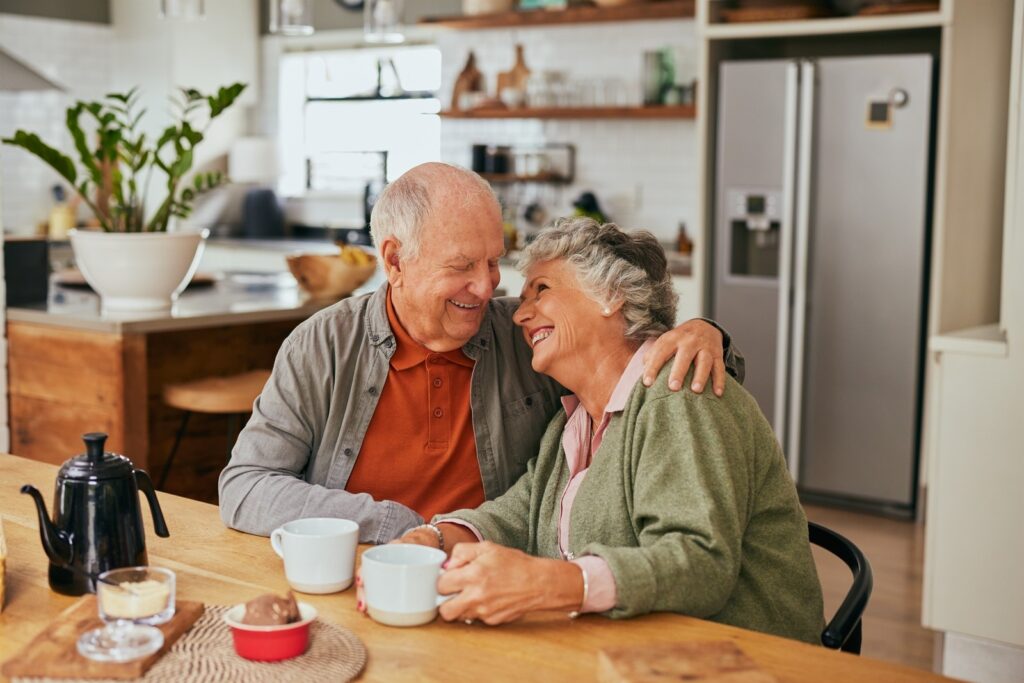 Elderly man and old woman laughing and looking at each other with love and affinity, enjoying their independence.